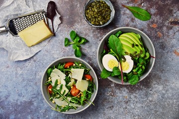 Two fresh salads bowls isolated on dark background. Flat lay salad bowls