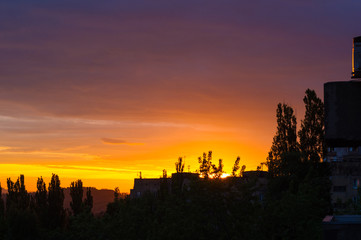 Landscape with dramatic light - beautiful golden sunset with saturated sky and clouds.