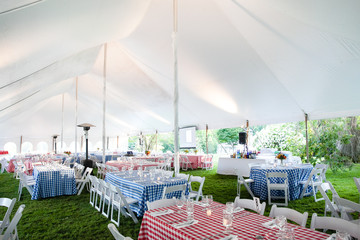 wedding or special event tables set up for an outdoor barbeque with red and blue checkered table...