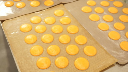 Obraz na płótnie Canvas Macaroons are laid out on several sheets of parchment paper for further drying out
