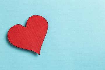 Fototapeta premium Valentine's Day. Red heart with copy space on cyan background