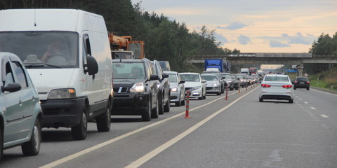 Naklejka premium Traffic jam - a lot of cars on the highway on a summer day at rush hour. Ecology, vehicle pollution