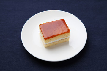 orange honey syrup cake on plate isolated on table