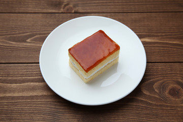 orange honey syrup cake on plate isolated on table