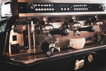 Coffee machine preparing fresh coffee in white cup.
