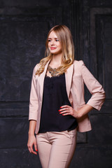 Fototapeta premium Fashion portrait of pretty sexy young blonde woman in pink pantsuit