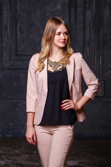 Fototapeta premium Fashion portrait of pretty sexy young blonde woman in pink pantsuit