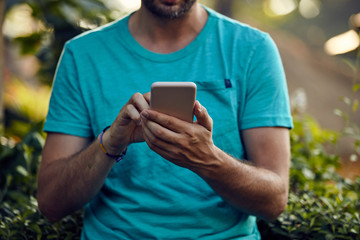 Fototapeta premium Modern man using cellphone outdoors.