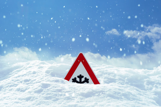 Achtung Schneefall. Verkehrsschild versinkt im Schnee