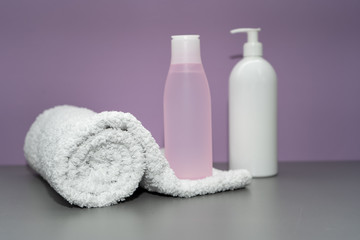 Obraz na płótnie Canvas Cosmetic bottles and towel in pink and white colors