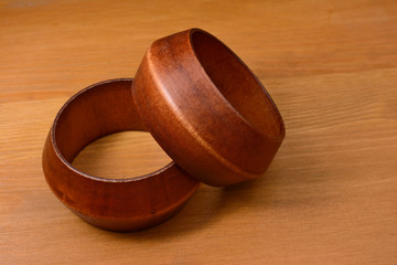 two wooden bracelets on a wooden background