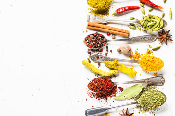 Set of various spices in spoons on white