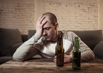 People, depression men and alcohol addiction concept. depressed man drinking alcohol at home alone