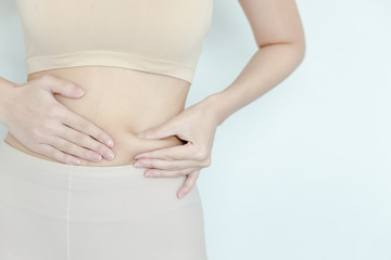 Women catch fat on the stomach to see how she reduced belly. girl testing fat layer on waist