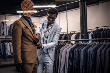 Fototapeta na wymiar A stylish elegantly dressed African-American man working at classic menswear store.