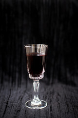 glass of red wine on a black velvet background, close-up