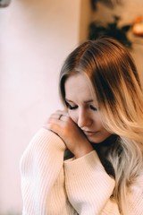 Fototapeta premium blonde girl in a cozy warm cafe, in a white knitted sweater 