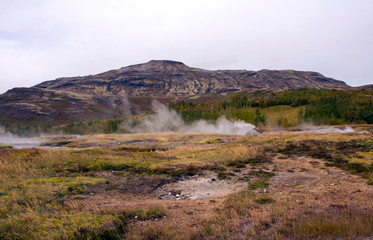 Beautiful view of the national park in the valley of Haukadalur, Iceland. View of the valley of geysers, hills and mountains, smoking sources.