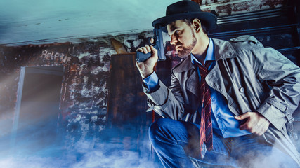Fototapeta na wymiar Detective with gun is carrying an investigation in the dark basement