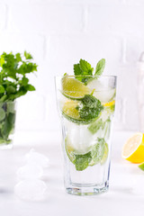 Tradition Summer drink mojito with lime and mint on white table