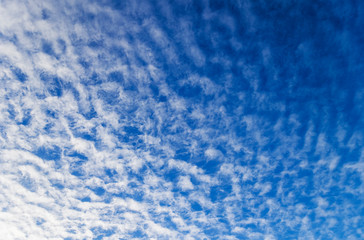 Blue sky with scattered cloud background