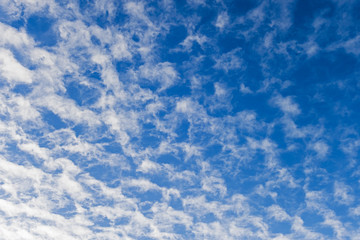 Blue sky with scattered cloud background