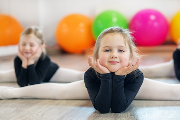 Fototapeta na wymiar Little girl doing stretching in training. The concept of sport, education, hobbies, training