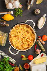 pasta, farfalle and sauce (set of ingredients). food background. copy space