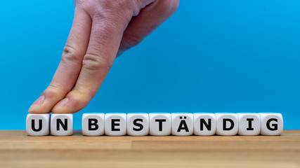 Zwei Finger schieben die Würfel mit den Buchstaben U und N zur Seite und verändern das aus...