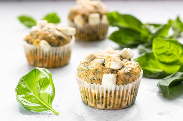 Freshly baked muffins with spinach and feta cheese. Light background. Copy space.