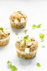 Freshly baked muffins with spinach and feta cheese. Light background. Copy space.