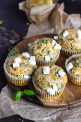 Savory muffins with spinach and feta cheese on old brown concrete background.
