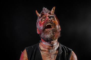 Halloween satan face with open mouth, beard, red blood, wounds