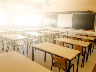 School classroom in blur background without young student; Blurry view of elementary class room no kid or teacher with chairs and tables in campus.