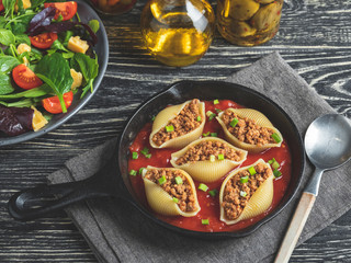 cooked pasta conchiglioni stuffed minced meat, tomato sauce