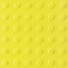 Yellow ceramic tile with rough surface and simple pattern. Yellow texture background.