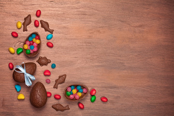 Flat lay Easter composition with chocolate eggs on color wooden background, space for text