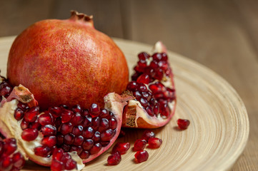 Obraz na płótnie Canvas open pomegranate and flat plate on wooden table