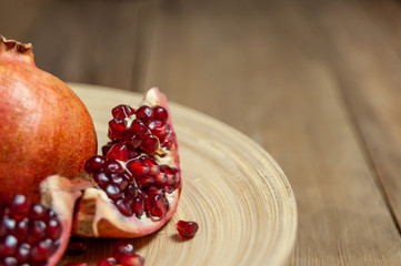 open pomegranate and flat plate on wooden table