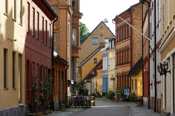 Very colorful, cobblestone, charming little street in Malmö, Sweden on beautiful, sunny summer day.