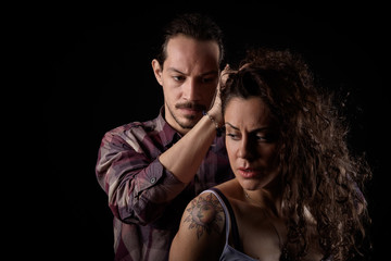 man threatening a scared woman in a gender violence case between a young couple arguing and...