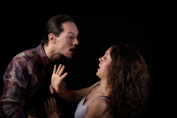 man threatening a scared woman in a gender violence case between a young couple arguing and struggling