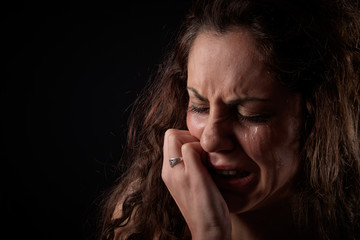 closeup portrait of a scared woman crying with bruises and wounds marks on her face after a case of...