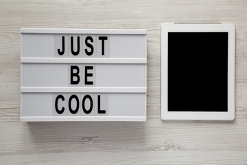 Modern board with text 'Just be cool' on a white wooden background, overhead view. From above, flat lay, top view. Close-up.