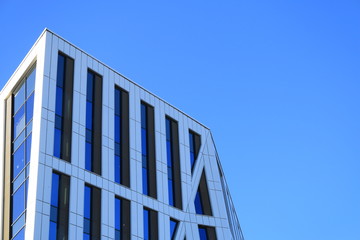 Top of a white and black office block. Top of an office block with white and black panels and an angled roof line.