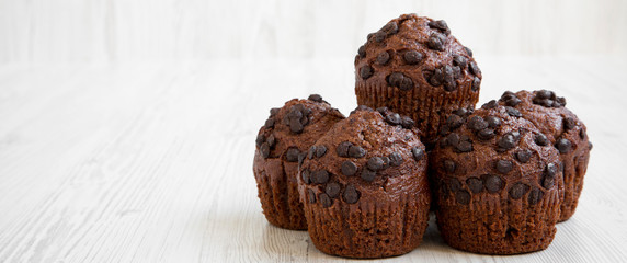 Chocolate cupcakes on white wooden table, side view. Space for text.