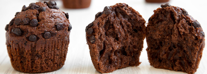 Chocolate muffins on white wooden table, side view. Closeup.