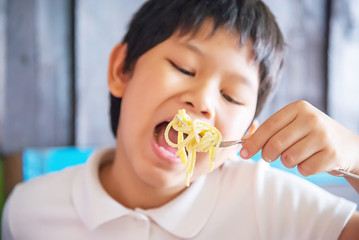 Boy eat delicious cream sauce spaghetti - Italian food with people concept