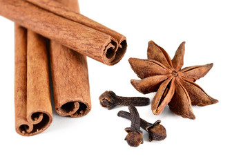 Set spices. Cinnamon sticks, star anise and buds cloves on a white background, isolated. Shallow depth of field, closeup.