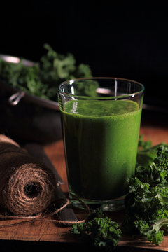 Glass with kale smoothie on a dark background
